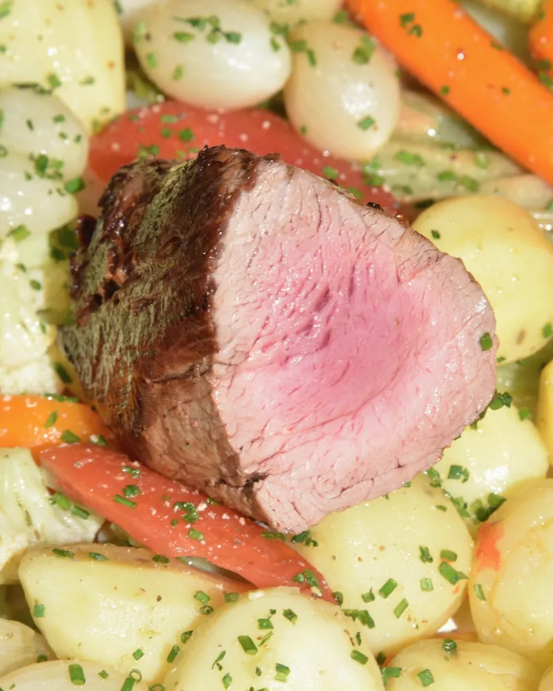 Filé mignon de vitelo rosado grelhado com legumes assados