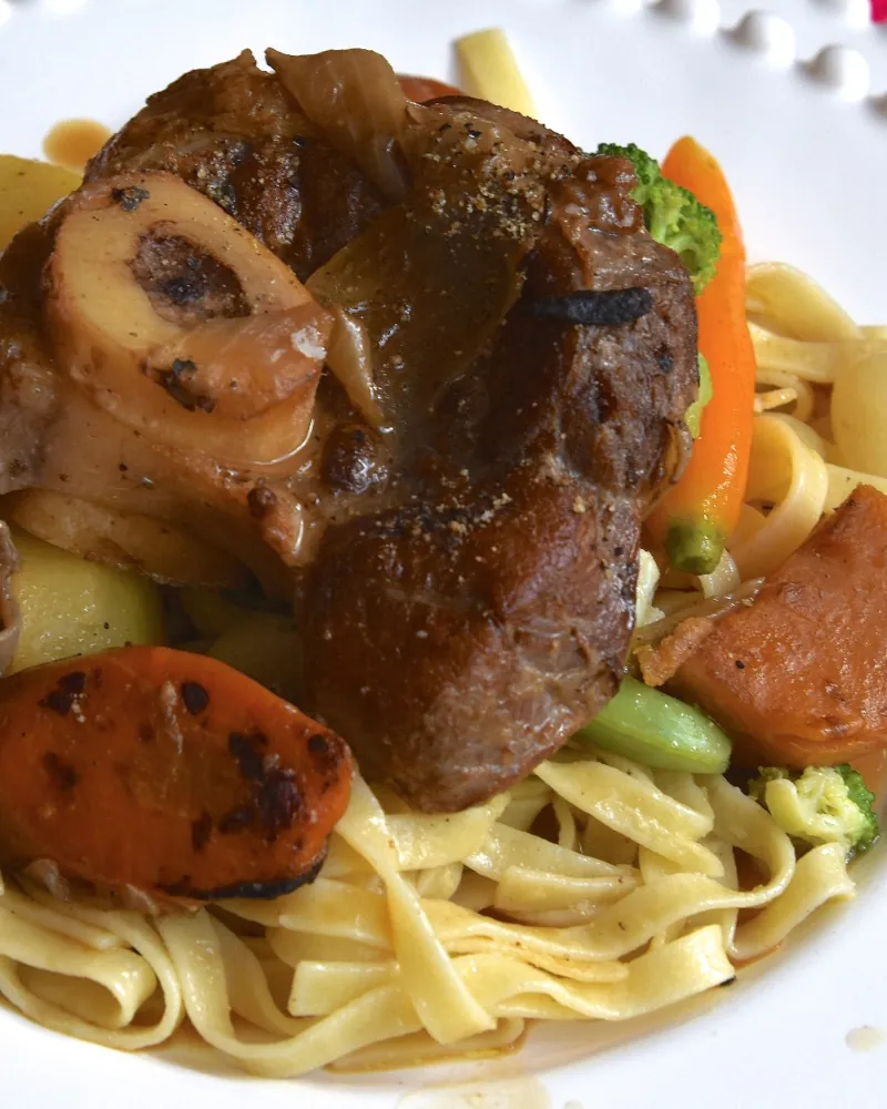 Ossobuco de vitelo rosado ao molho sobre talharim